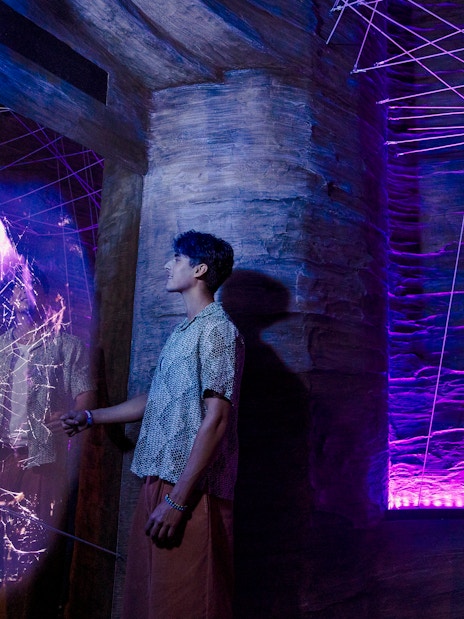 Visitors exploring cave spider exhibit at Exploria, Mandai Wildlife, with interactive web display.