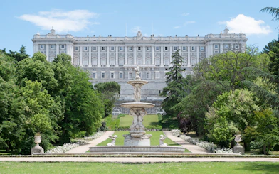 Royal Palace of Madrid exterior with fountain and gardens.