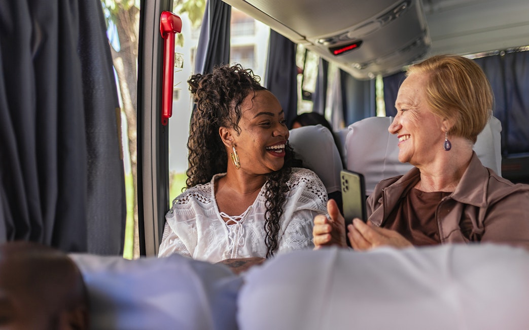 Customers smiling on air-conditioned bus during Herculaneum tour from Naples.