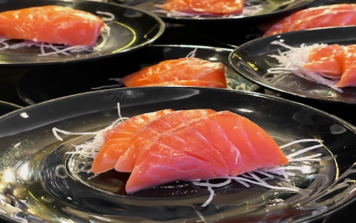 Sashimi served on black plates, part of the Bangkok Chao Phraya Princess Cruise dining experience.