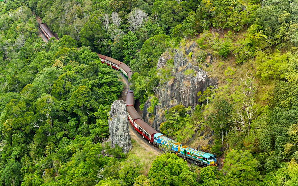 Kuranda Scenic Railway winding through lush rainforest in Queensland.