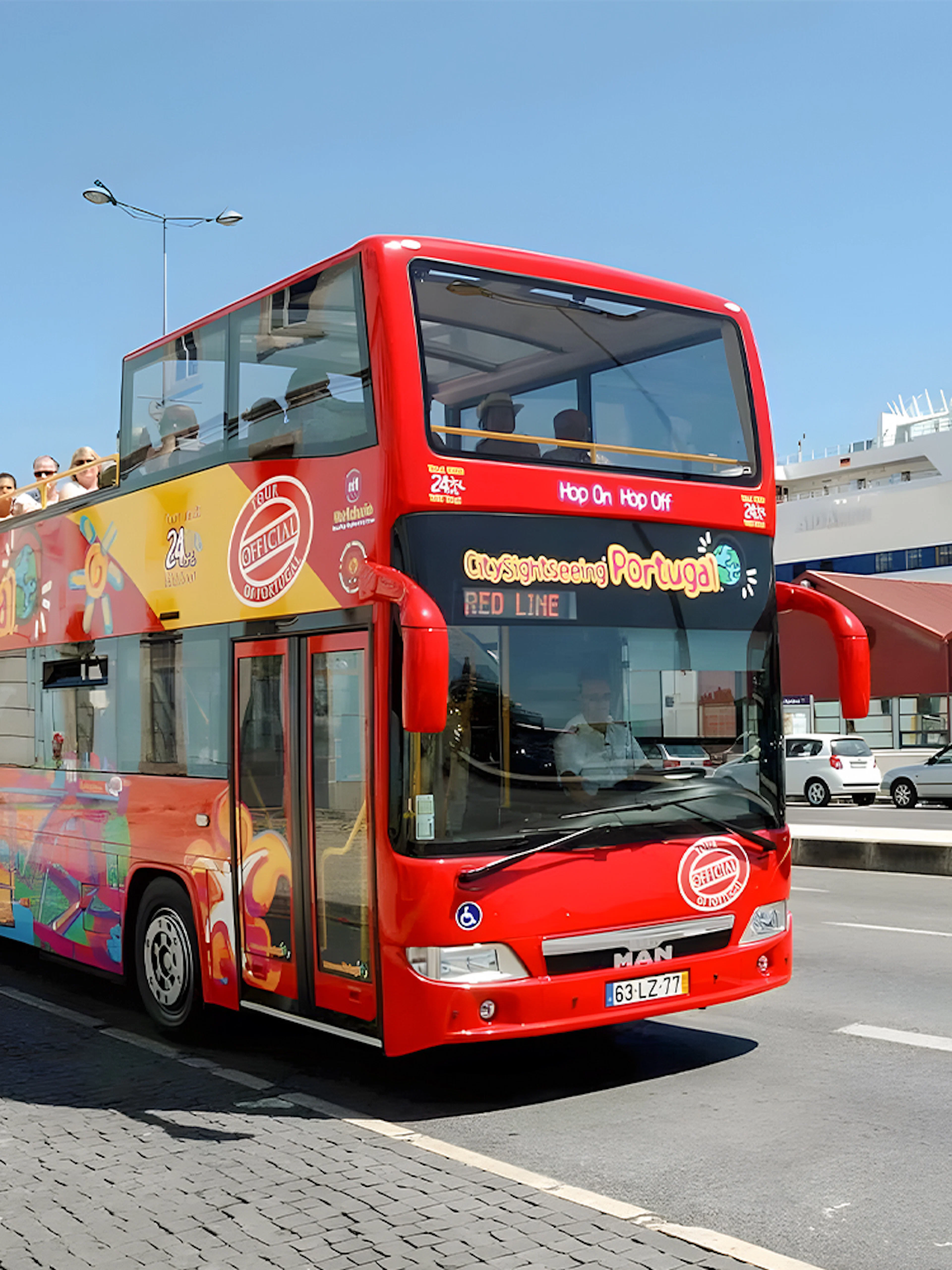Lisbon hop-on hop-off sightseeing bus on city street near cruise ship terminal.