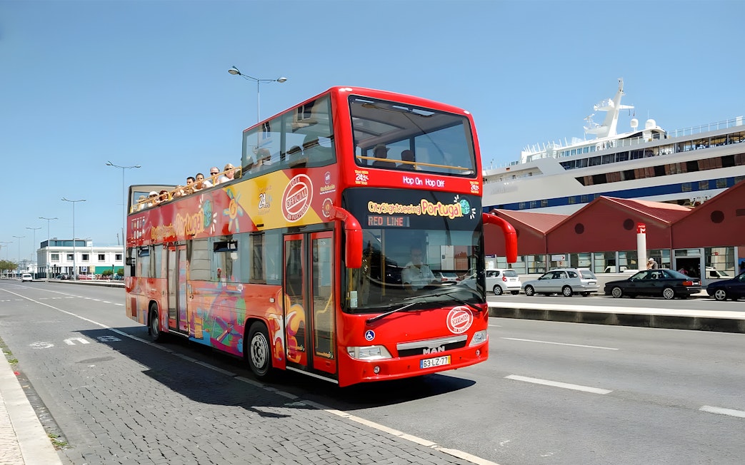 Lisbon hop-on hop-off sightseeing bus on city street near cruise ship terminal.