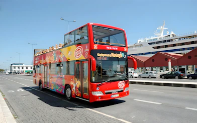Lisbon hop-on hop-off sightseeing bus on city street near cruise ship terminal.