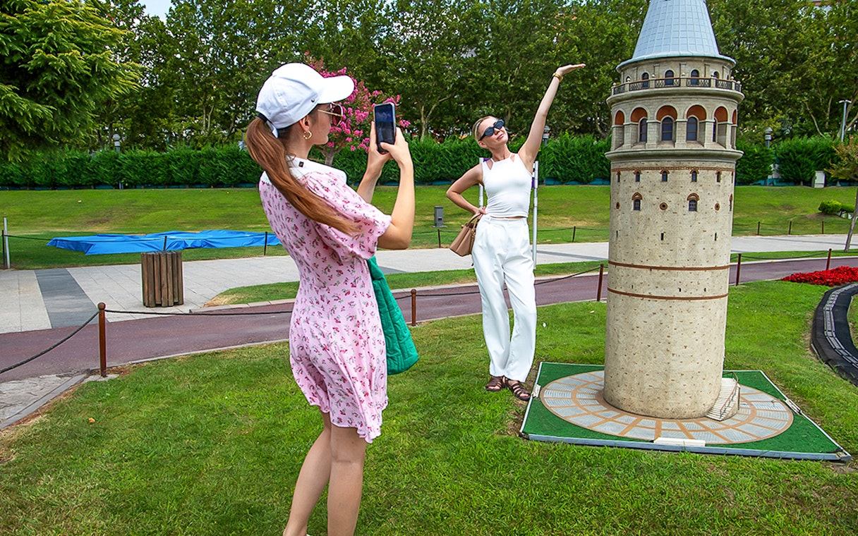 Guests taking photos at Miniatürk park in Istanbul with a Galata Tower model.