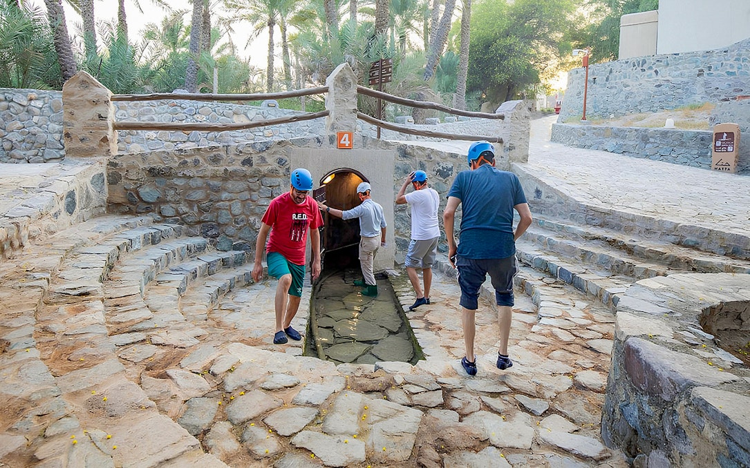 Visitors exploring Hatta Falaj water channel on a guided tour.