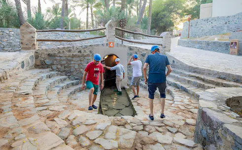 Visitors exploring Hatta Falaj water channel on a guided tour.