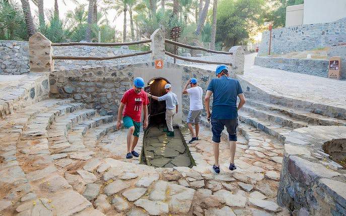 Visitors exploring Hatta Falaj water channel on a guided tour.