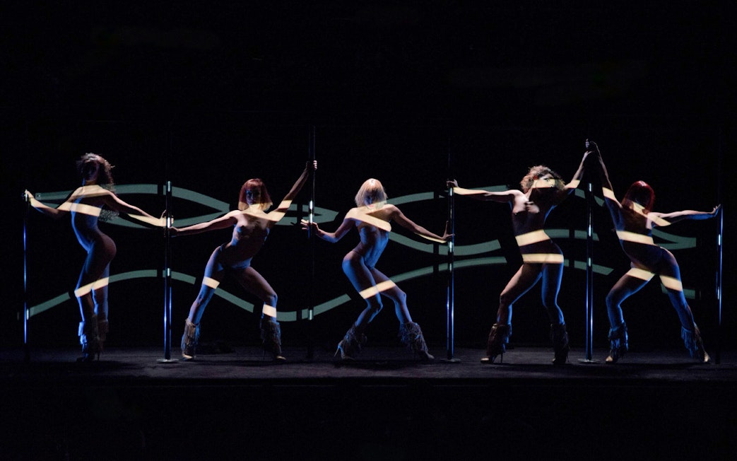 Dancers performing at Crazy Horse Paris show with dynamic lighting effects.