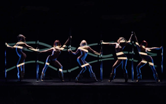 Dancers performing at Crazy Horse Paris show with dynamic lighting effects.