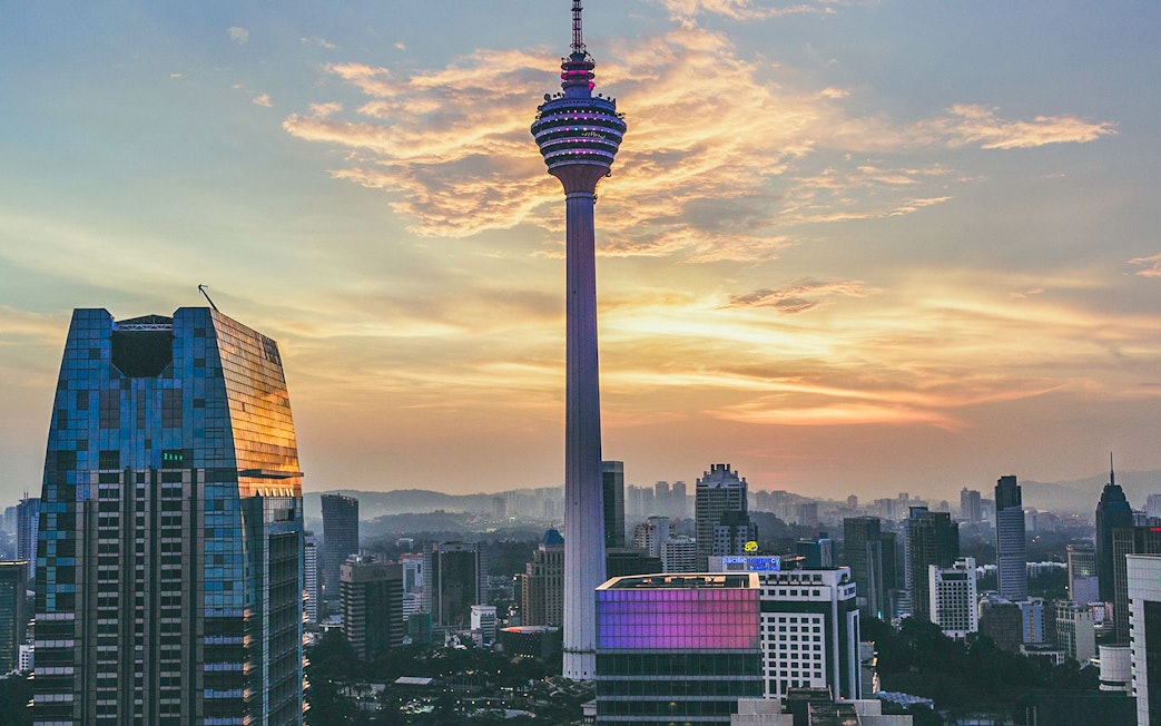 KL Tower at sunset with city skyline, Kuala Lumpur.