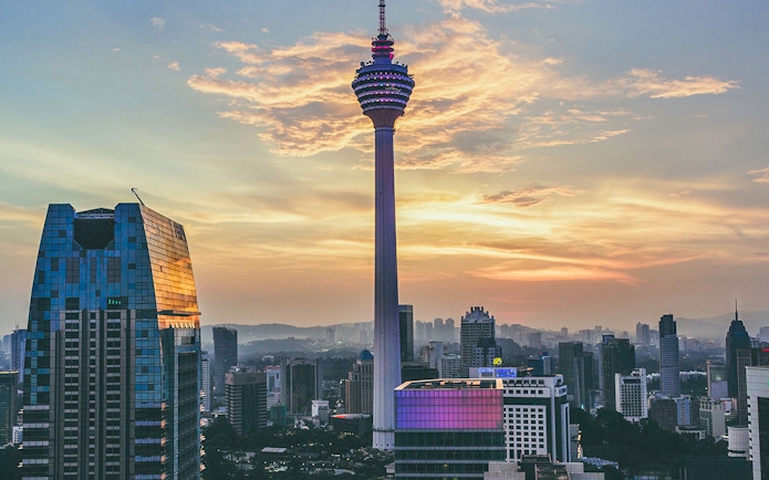 KL Tower at sunset with city skyline, Kuala Lumpur.