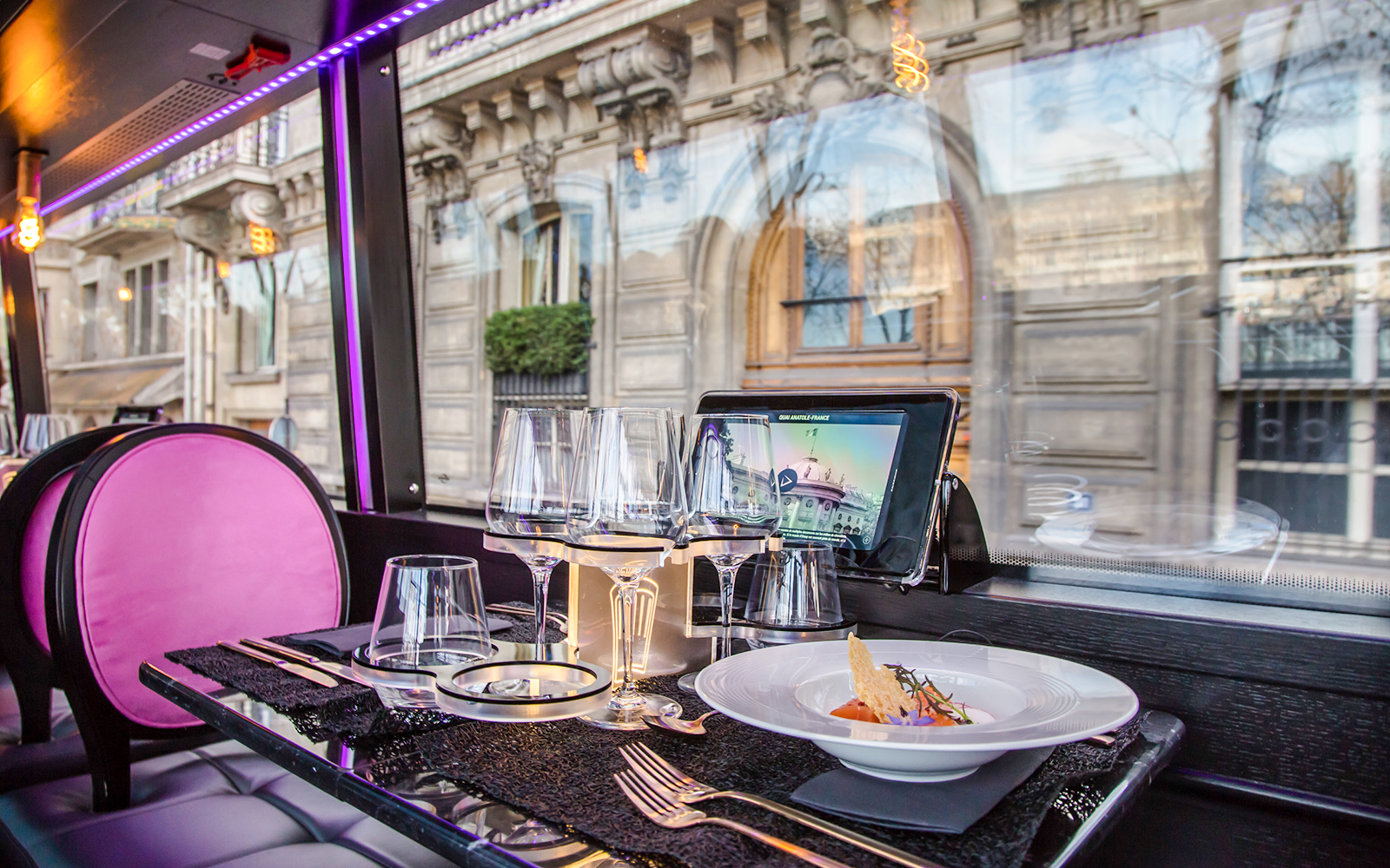 Dining setup inside Bus Toqué Paris with street view through window.