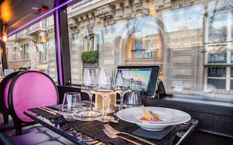 Dining setup inside Bus Toqué Paris with street view through window.