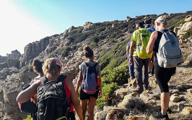 Group hiking in Manago Stone Garden, rocky trail with backpacks.
