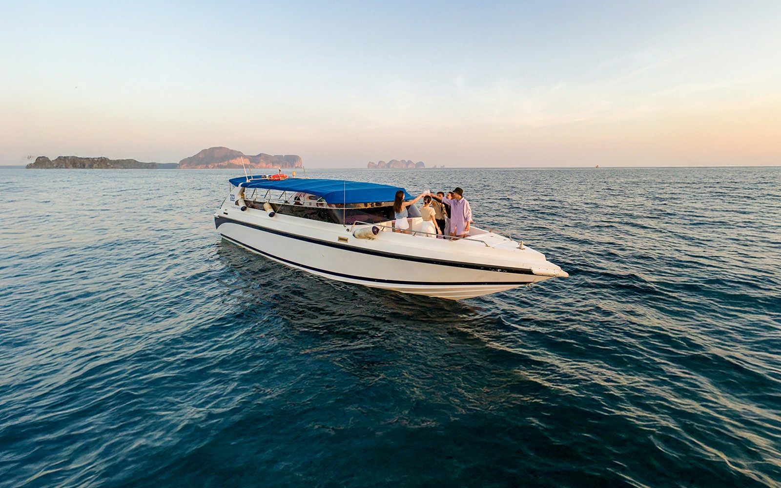 Speedboat with people at sunset near Phi Phi Islands, Thailand.