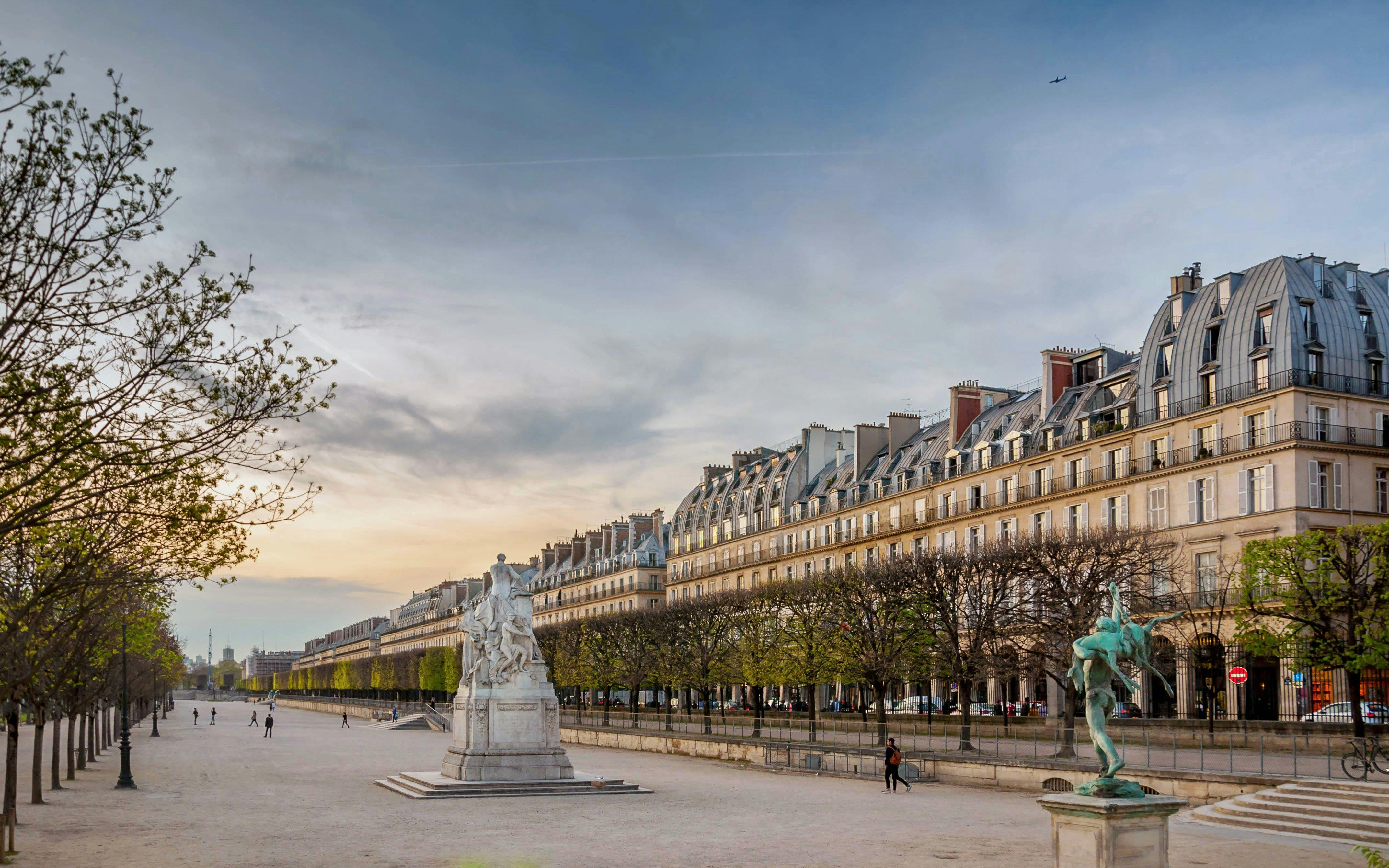 Rue de Rivoli in Paris with historic buildings and statues at sunset.