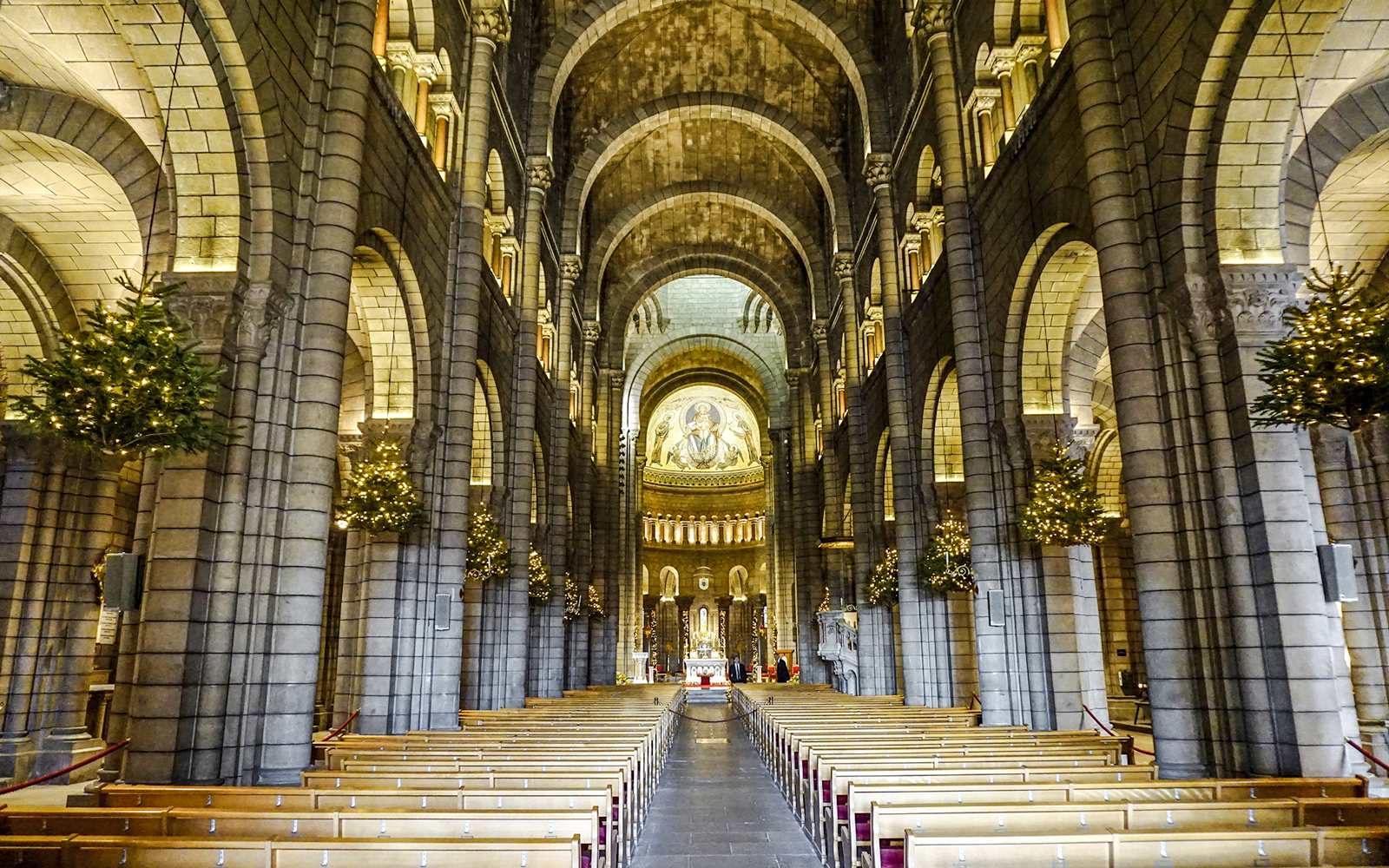 Interior of Cathedral of Monaco with arches and illuminated altar.