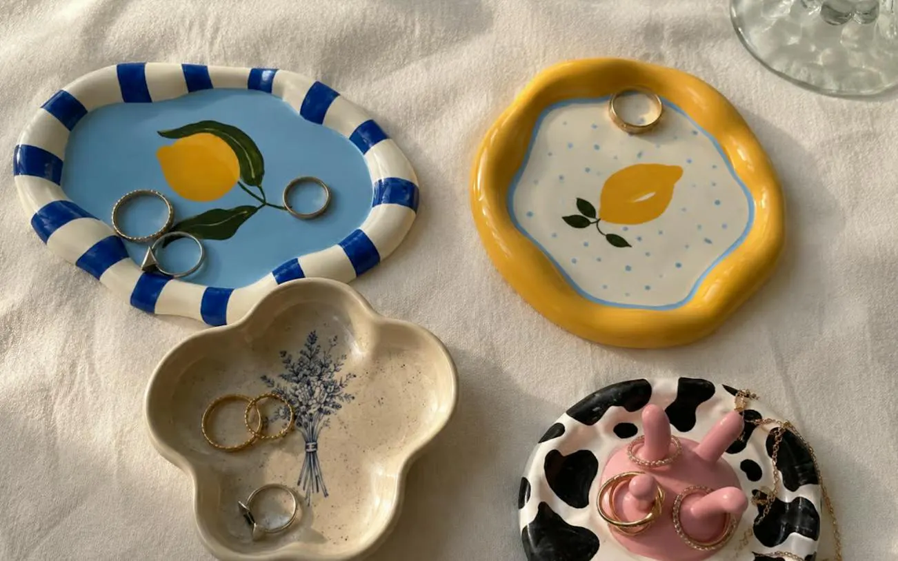 Handcrafted clay dishes with painted designs and rings from Krakow workshop.