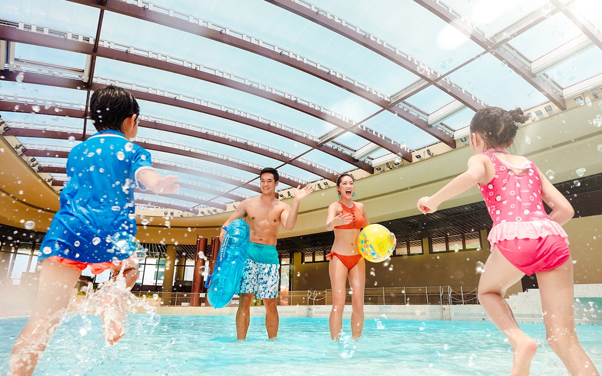 Family playing in the wave pool at Water World Ocean Park, Hong Kong.