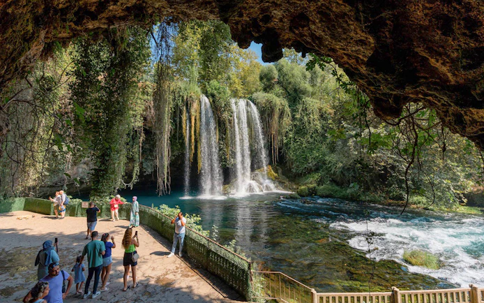Waterfall view with tourists in Antalya during sightseeing city tour.