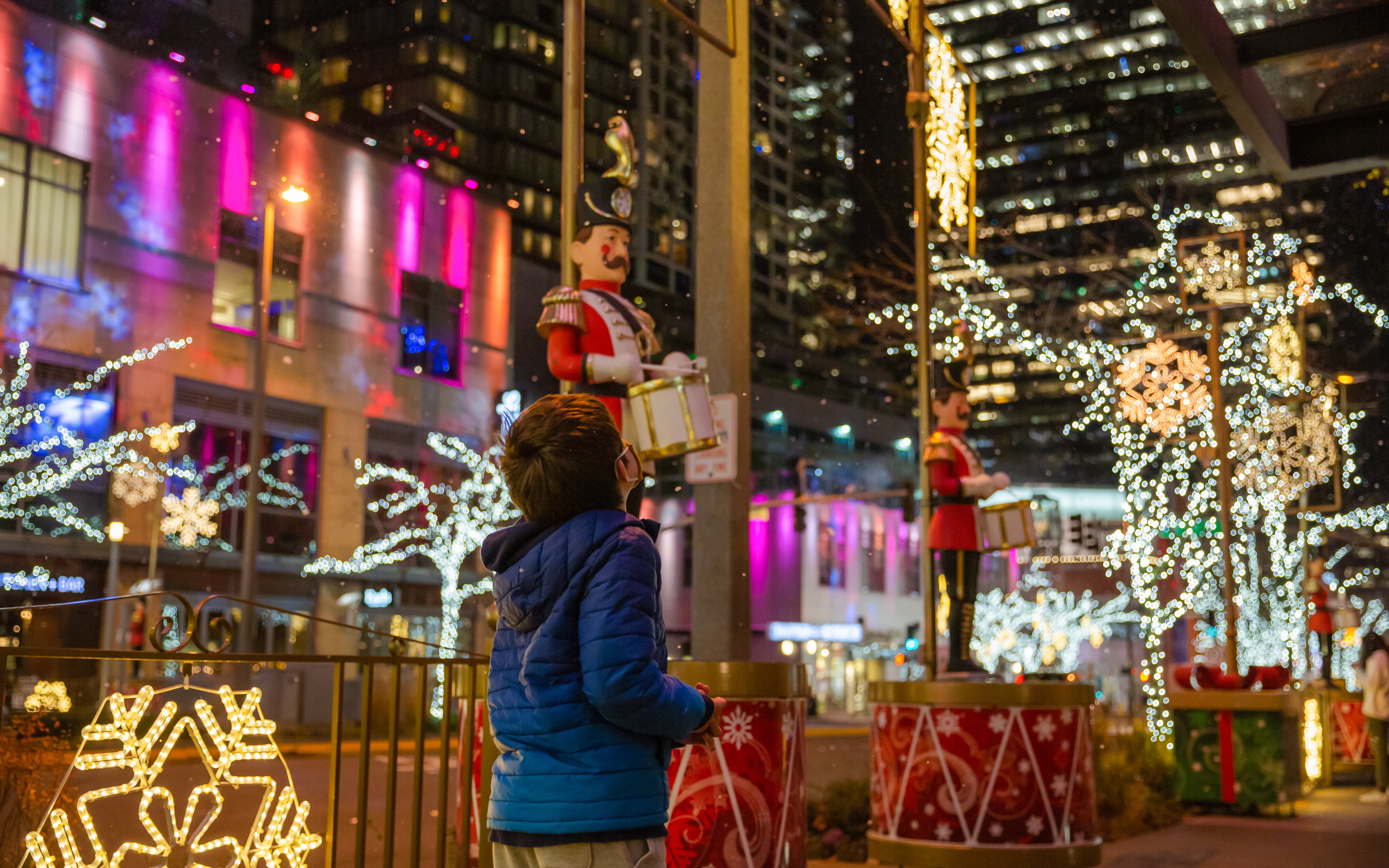 Boy admiring festive Christmas lights and decorations in downtown Seattle.
