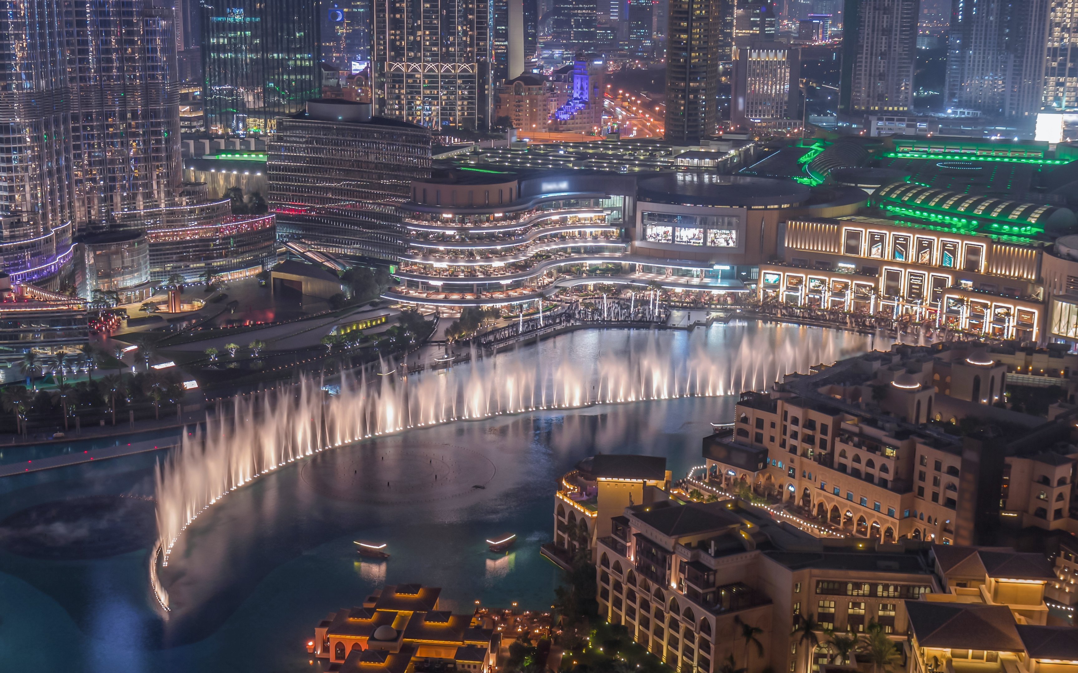 Dubai Canal with illuminated skyline and fountain show at night.