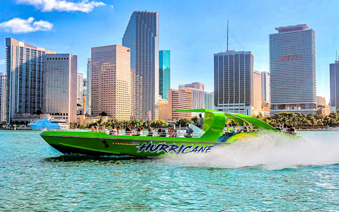 Speedboat named Hurricane cruising past Miami skyline.