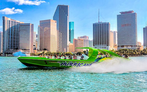 Speedboat named Hurricane cruising past Miami skyline.