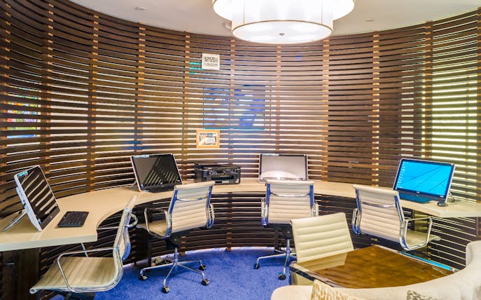 Work station with computers and chairs at Ambassador Transit Lounge, Terminal 3, Changi Airport.