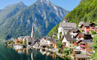 Hallstatt village with lakeside view and church, surrounded by mountains, on a day trip from Munich.