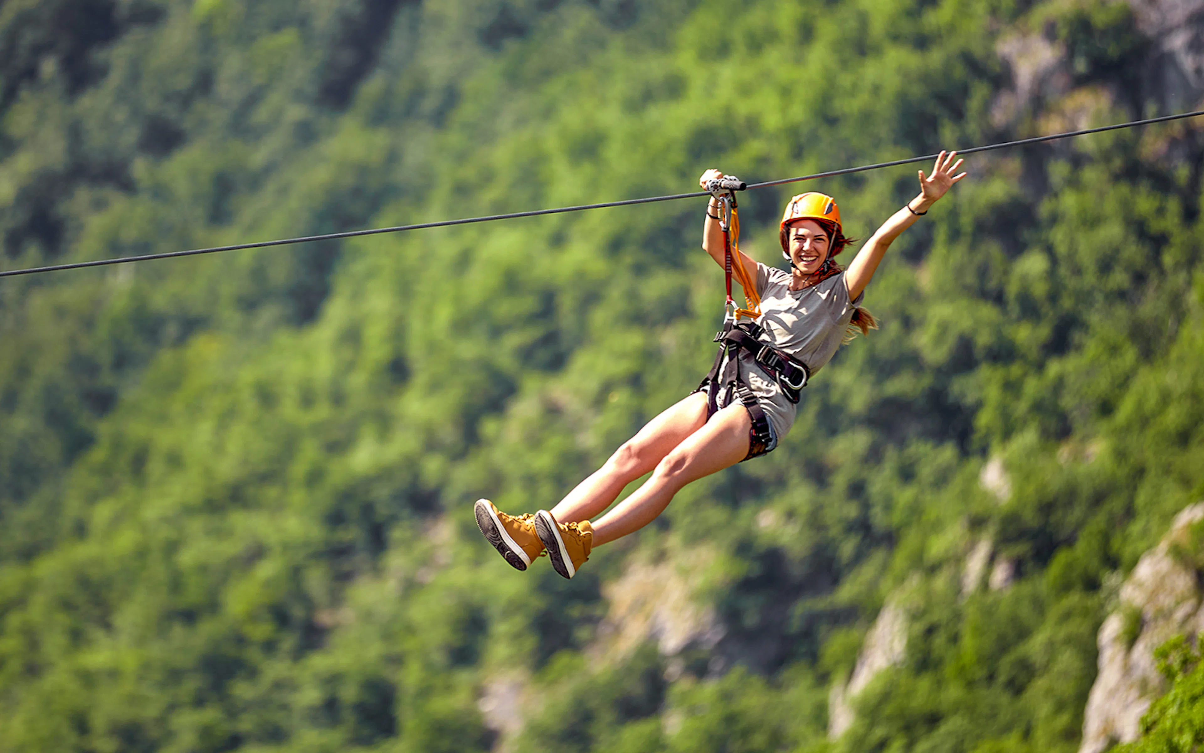 Female tourist ziplining through lush forest canopy in Costa Rica.