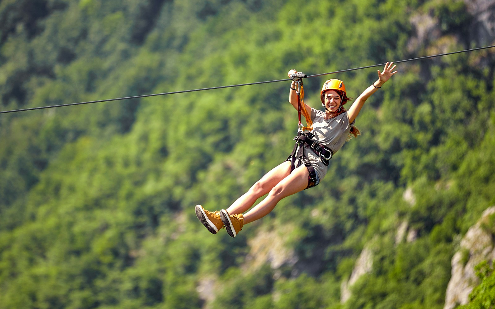 Female tourist ziplining through lush forest canopy in Costa Rica.
