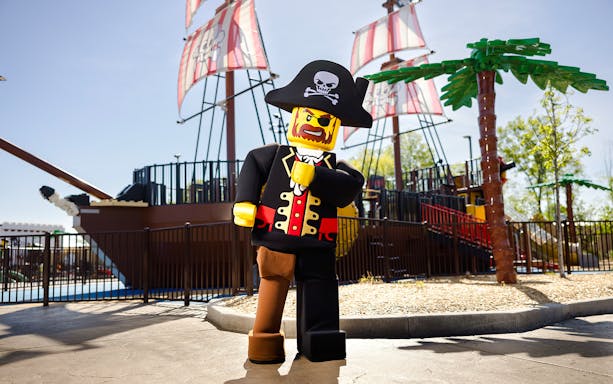 Lego pirate character in front of a pirate ship at Legoland New York.