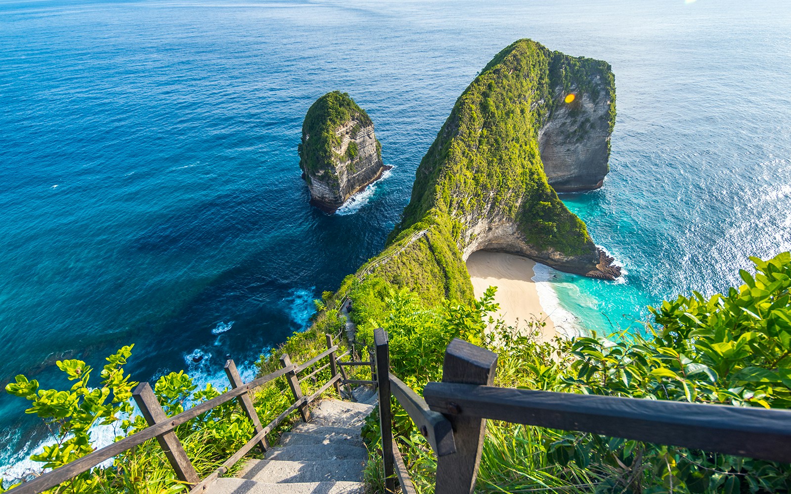 Breathtaking view of Kelingking Beach, Bali, with turquoise waters, white sandy beach, and towering cliffs, a unique destination for a day trip.