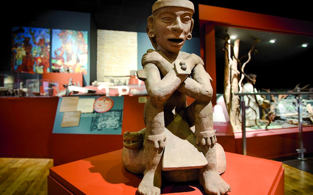 Artefact in Chocolate Museum Paris depicting a seated figure with crossed arms.