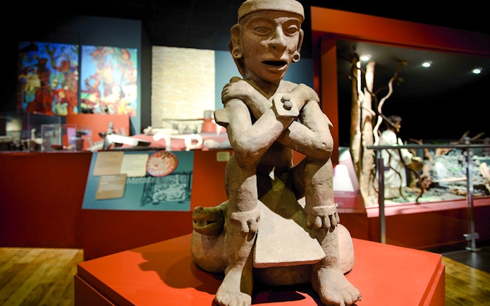 Artefact in Chocolate Museum Paris depicting a seated figure with crossed arms.