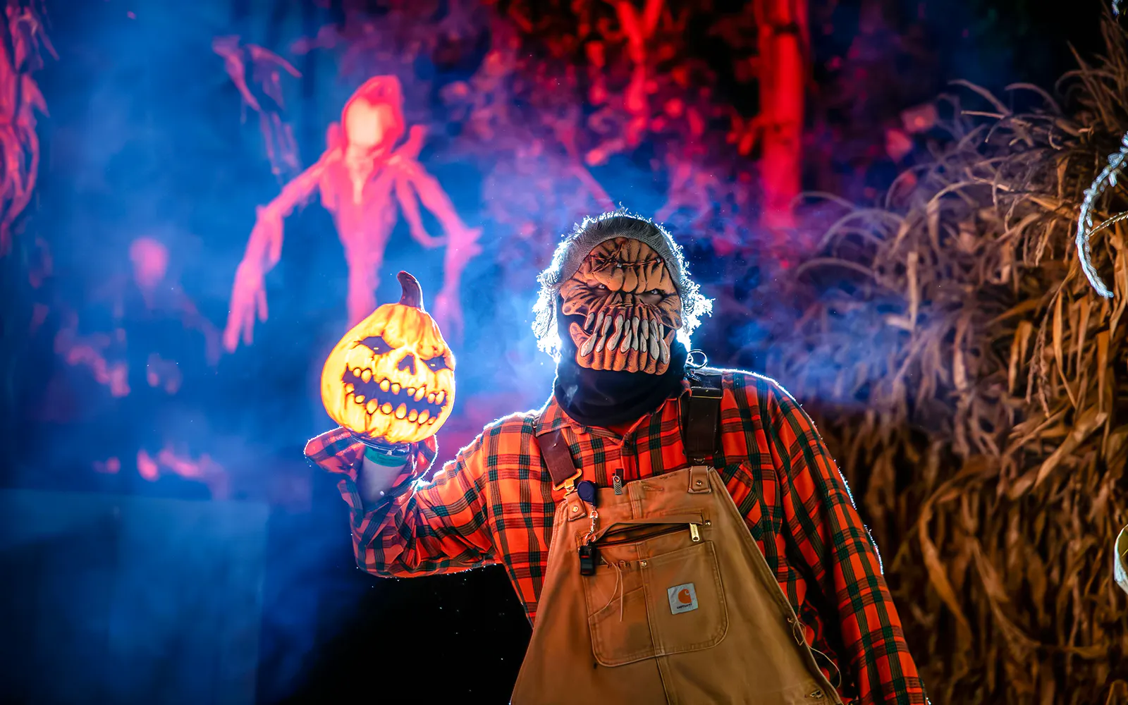 Halloween character holding pumpkin lantern in Dorney Park haunt zone.