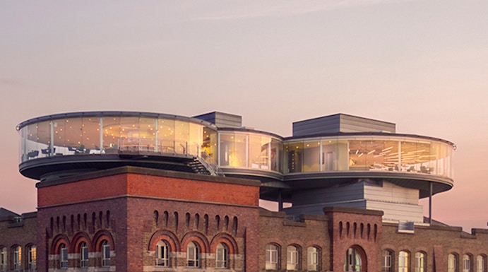 Guinness Storehouse rooftop view with glass-walled Gravity Bar at sunset, Dublin.