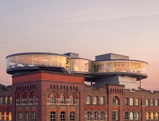 Guinness Storehouse rooftop view with glass-walled Gravity Bar at sunset, Dublin.