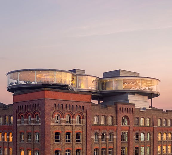 Guinness Storehouse rooftop view with glass-walled Gravity Bar at sunset, Dublin.