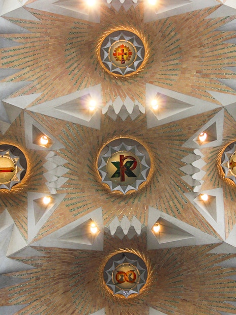 Ceiling detail of Sagrada Familia with geometric patterns and symbols, Barcelona.