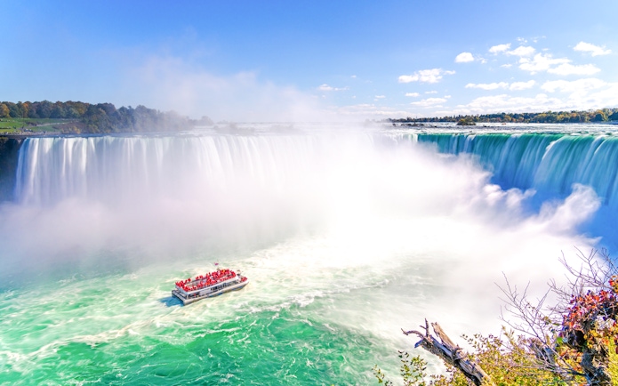 Tour boat approaching Niagara Falls with mist rising, Ontario, Canada.
