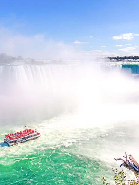 Tour boat approaching Niagara Falls with mist rising, Ontario, Canada.