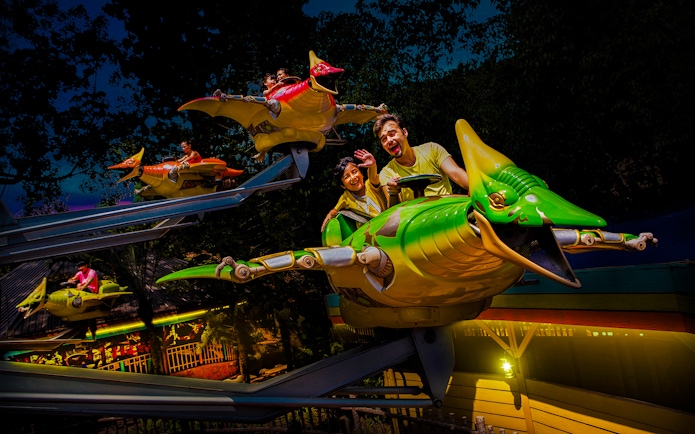Riders enjoying a flying dinosaur ride at Sunway Lagoon night park.