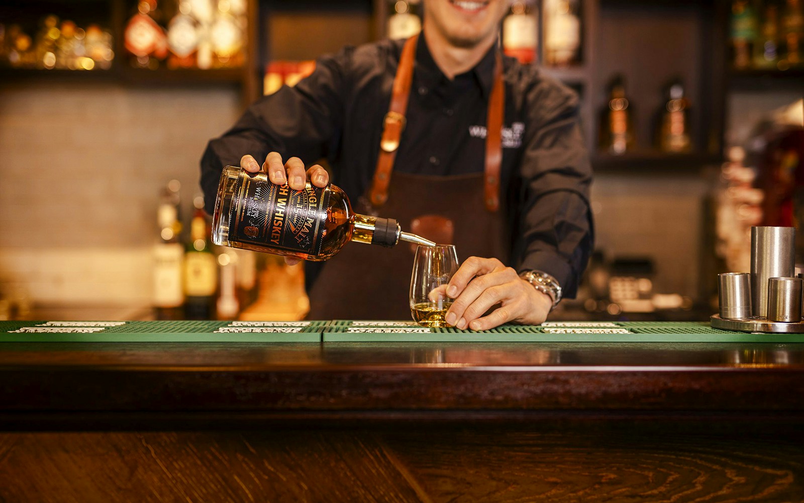Whiskey being poured into a glass at the Irish Whiskey Museum bar.