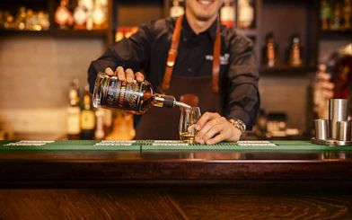 Whiskey being poured into a glass at the Irish Whiskey Museum bar.