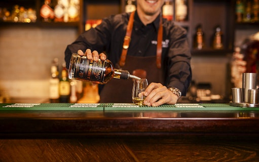 Whiskey being poured into a glass at the Irish Whiskey Museum bar.