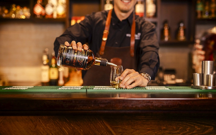 Whiskey being poured into a glass at the Irish Whiskey Museum bar.