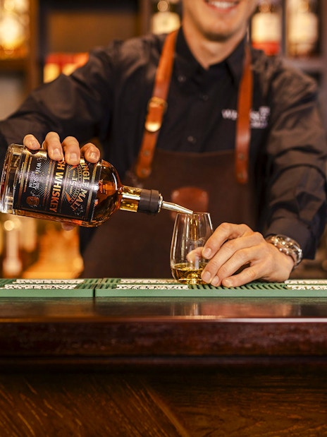 Whiskey being poured into a glass at the Irish Whiskey Museum bar.